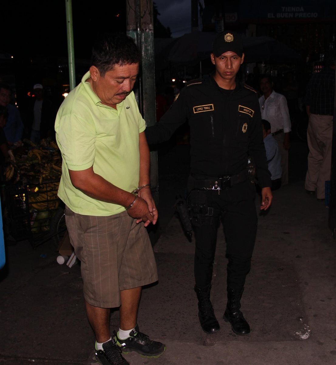 Juan Gelber Solís Contreras, de 54 años, es custodiado por un agente de la PNC. (Foto Prensa Libre: Enrique Paredes)
