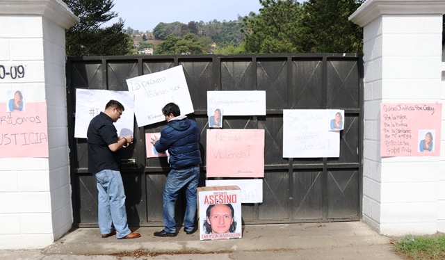 Amigos y familiares colocan carteles en la vivienda donde se presume ocurrieron los hechos. (Foto Prensa Libre: María José Longo)