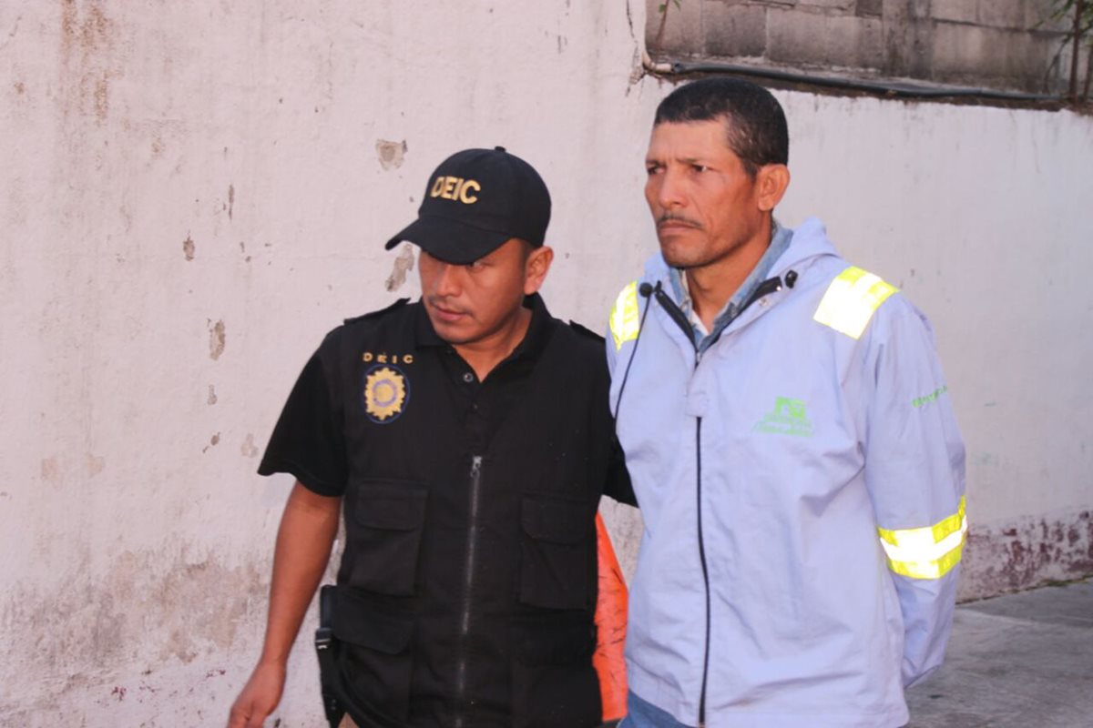 Santos Reyes Palacios es resguardado por un agentes de la Policía Nacional Civil. Es sospechoso de haber asesinado a su esposa. (Foto Prensa Libre: Enrique Paredes)