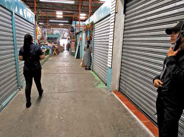 Agentes uniformados y con arma de fuego protegen comercios en todo el país, ante el posible aumento de la criminalidad por la temporada del año.