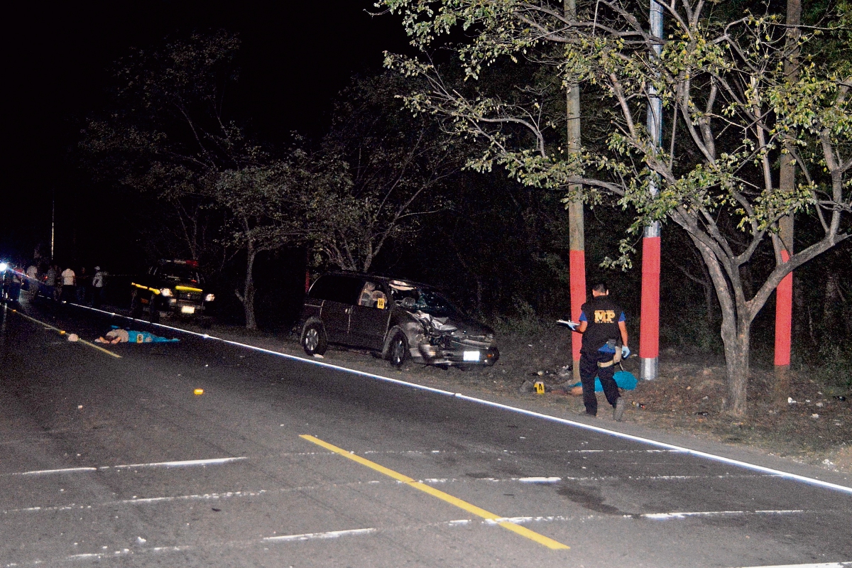Autoridades examinan el lugar donde murieron dos motociclistas que chocaron de frente contra un automóvil, en Zacapa. (Foto Prensa Libre: Víctor Gómez)