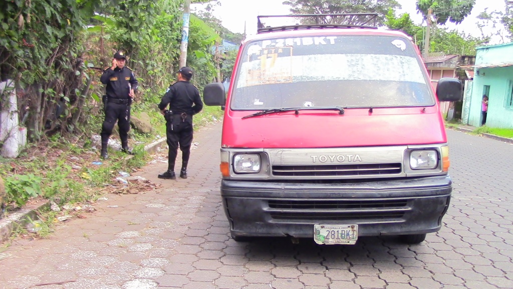 Agentes de la PNC cuidan sitio donde ocurrió el ataque aramdo a microbús, en Mazatenango, Suchitepéquez. (Foto Prensa Libre: Melvin Popá)