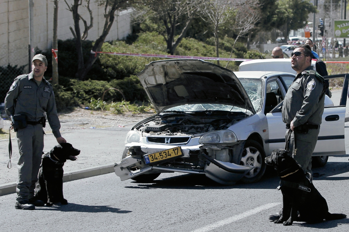 Policías israelíes  cuidan el lugar del  atentado en donde un carro atropelló a varios guardias de seguridad. (Foto Prensa Libre: AFP)