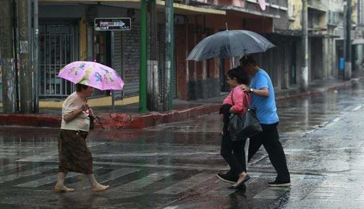 Personas caminan en una calle de la zona 1 durante una tarde de lluvia (Foto Prensa Libre: Hemeroteca PL)