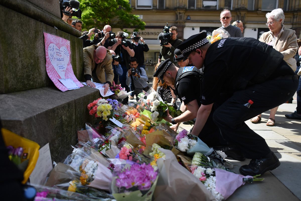 Policías colocan arreglos florales fuera del lugar del ataque, en Mánchester, Reino Unido. (Foto Prensa Libre: AFP)