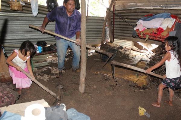 Niñas ayudan a su padre a sacar lodo de su vivienda, en el caserío Tierra Blanca, Nueva Santa Rosa. (Foto Prensa Libre: Oswaldo Cardona)<br _mce_bogus="1"/>