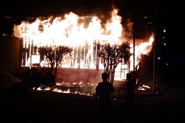 Vecinos de la zona 1 de Mazatenango observan el incendio en una vivienda. (Foto Prensa Libre: Omar Méndez)