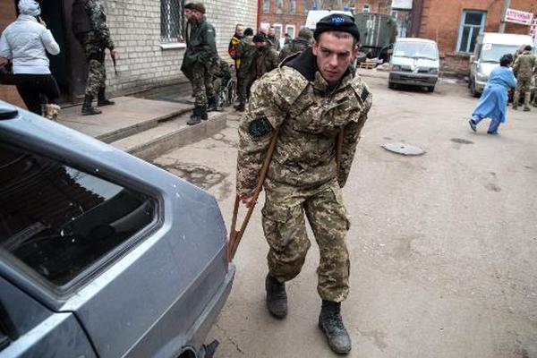 Un miliciano ucraniano camina ayudado por muletas junto al hospital  militar de Artemivsk, en el este de Ucrania, a donde debieron huir  cuando los rebeldes tomaron Debáltsevo. (Foto Prensa Libre: AFP)