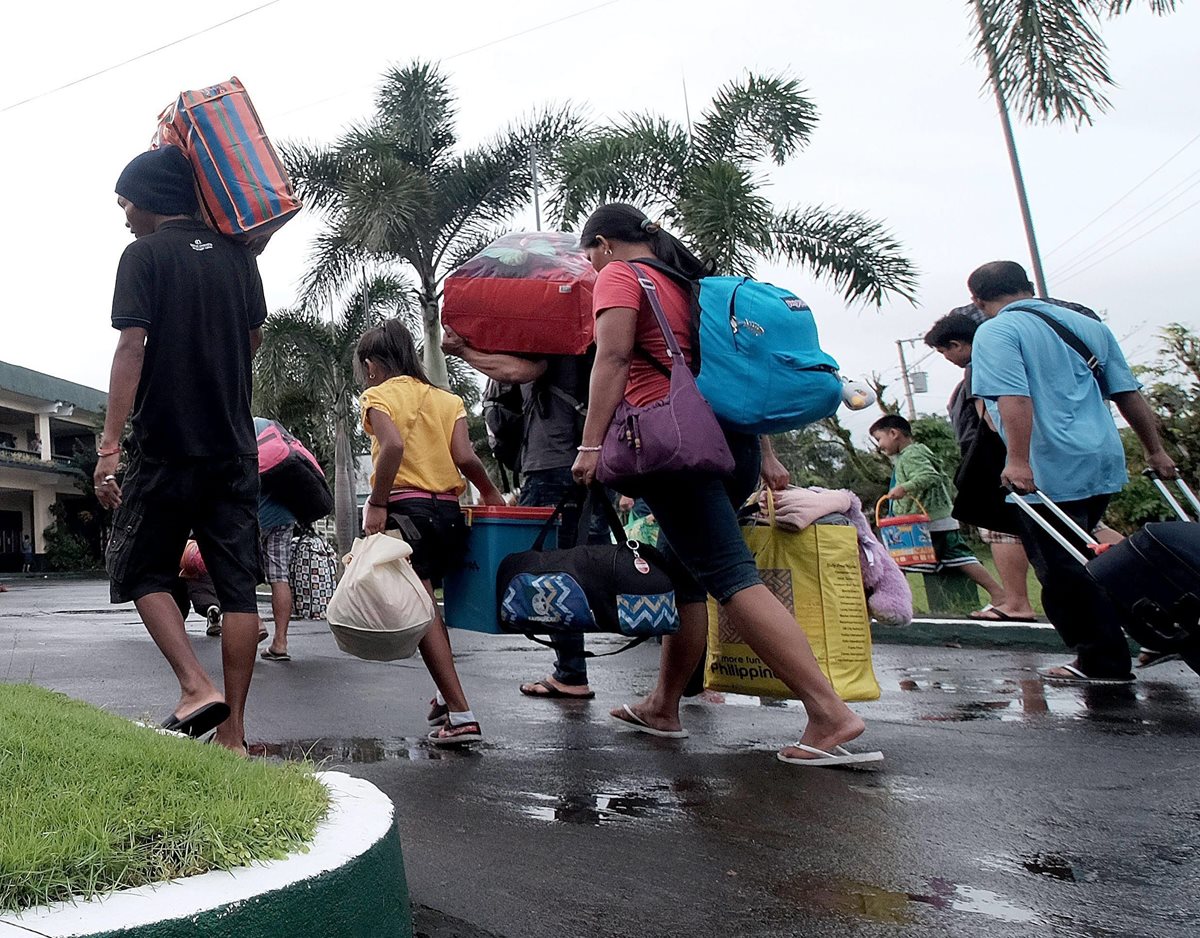 Varias personas abandonan la ciudad de Tabaco, provincia de Albay, Filipinas. (Foto Prensa Libre: EFE).