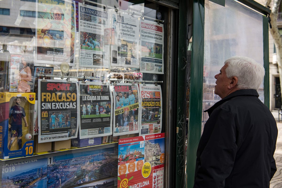 Una persona lee las portadas de los periódicos españoles en un kiosko.(Foto Prensa Libre: AFP)