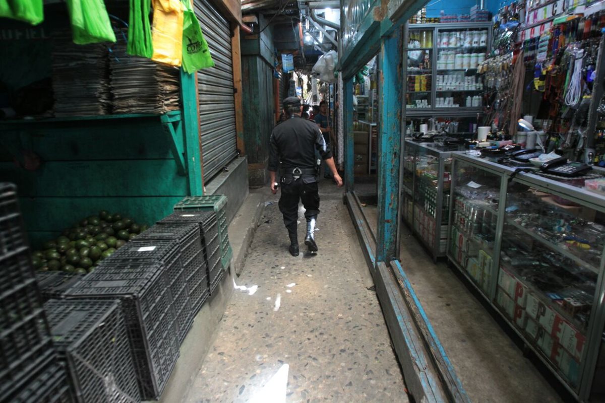 Un investigador de la PNC revisa los comercios cercanos al lugar del incidente, en busca de evidencias. (Foto Prensa Libre: Érick Avila)