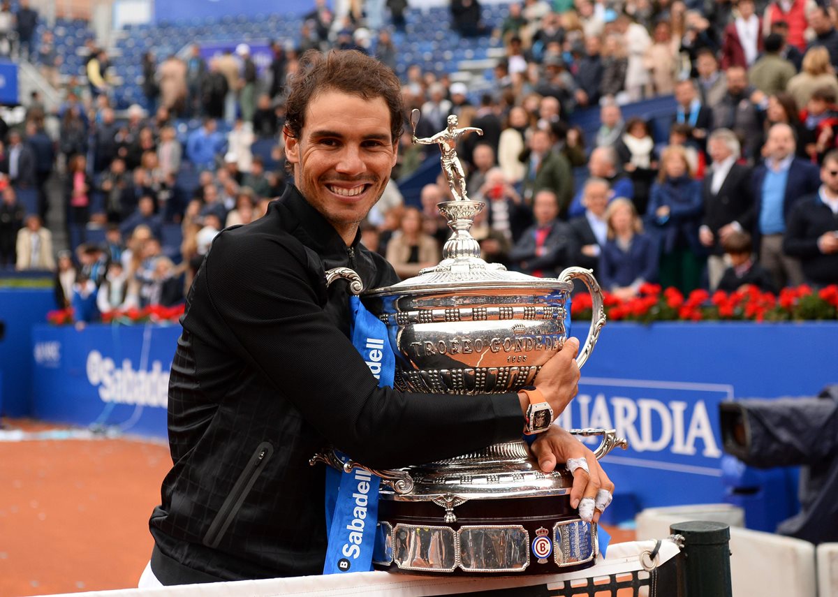 Rafael Nadal abraza su décimo trofeo del abierto de Barcelona. (Foto Prensa Libre: AFP)