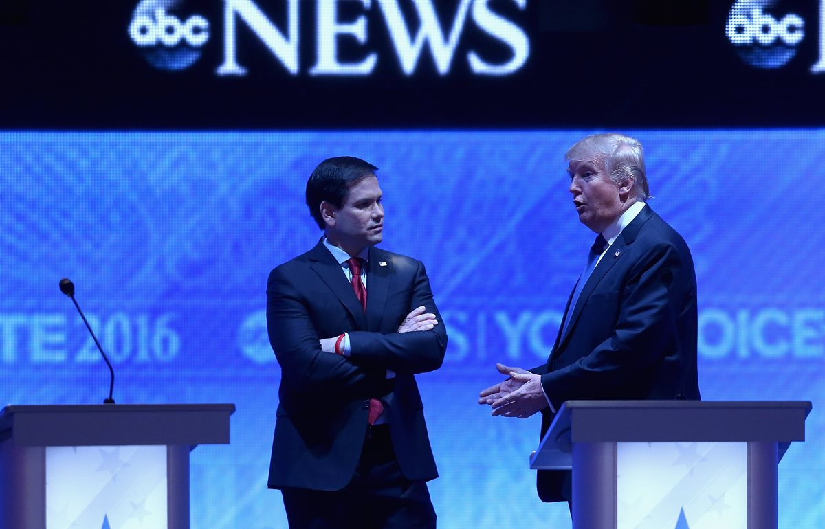 Marco Rubio (izq.) conversa con Donald Trump durante el debate presidencial republicano en New Hampshire. (Foto Prensa Libre: AFP).