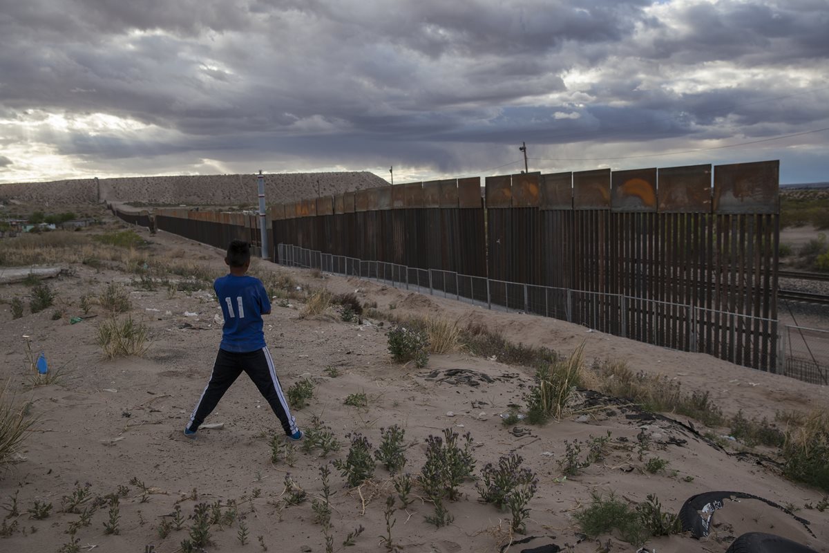 Un joven observa el muro en Ciudad Juárez, México. (Foto Prensa Libre: AP)