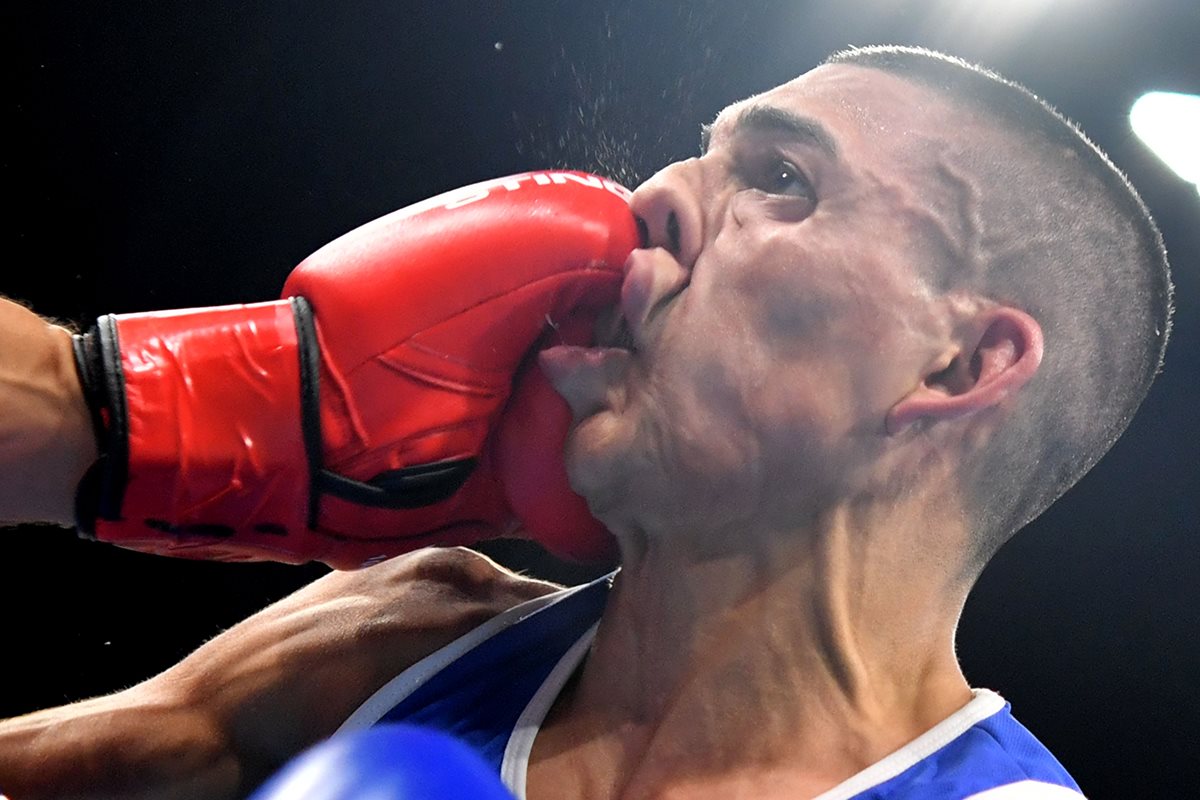 Teófimo López recibe un fuerte puñetazo de Sofiane Oumiha durante su debut en Río. (Foto Prensa Libre: AFP)