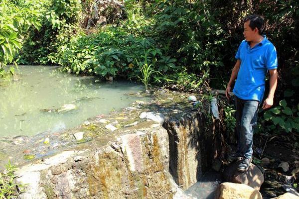 Un vecino muestra cómo los desechos se quedan estancados en un riachuelo. (Foto Prensa Libre: Rolando Miranda)