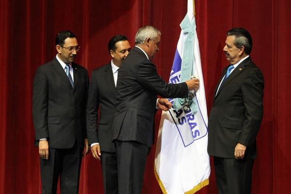 El presidente  de Guatemala, Otto Pérez, impone  la Orden del Quetzal a la bandera de Emisoras Unidas.  (Foto Prensa Libre: Edwin Castro)