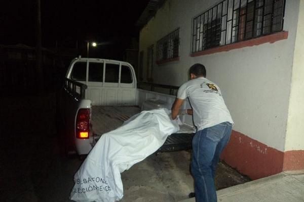 Empleado de una funeraria traslada a la morgue de Chiquimula el cadáver de Eulogio Ramírez, quien murió baleado, en Olopa. (Foto Prensa Libre: Edwin Paxtor)