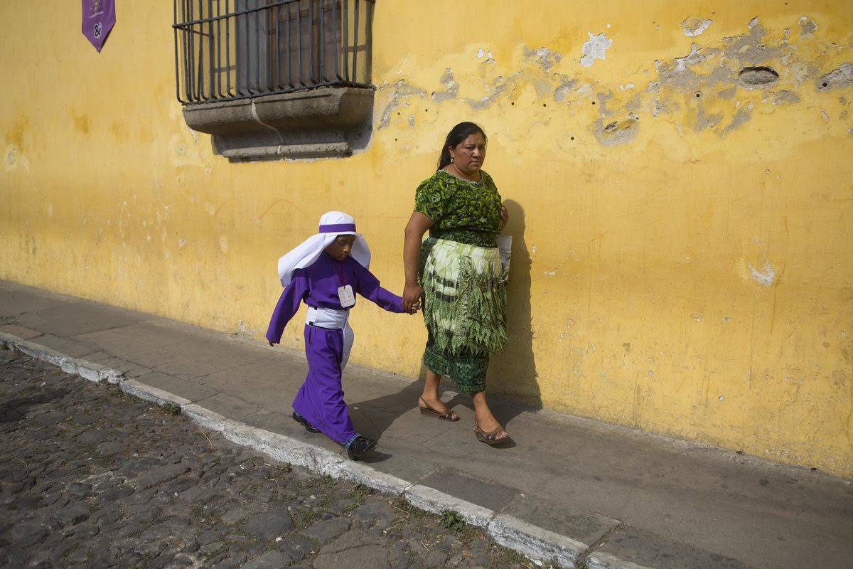 Una mujer indígena acompaña a un pequeño cucurucho. (Foto Prensa Libre: AP)