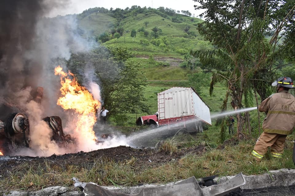 Bomberos apagan las llamas de un tráiler incendiado, en la cuesta de El Manacal, kilómetro 193 de la ruta al Atlántico, Los Amates, Izabal. (Foto Prensa Libre: Dony Stewart)