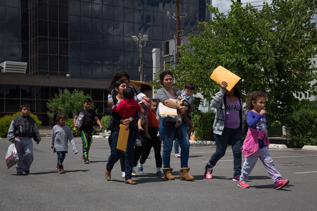 Un grupo de inmigrantes centroamericanos caminan después de ser dejados en una estación de autobuses poco después de ser liberados en McAllen, Texas. (Foto Prensa Libre:AFP)