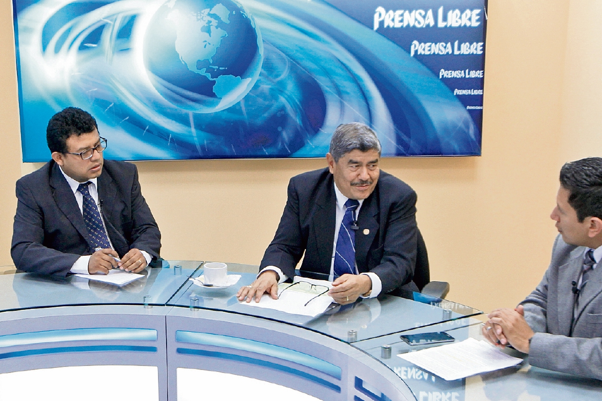 El contralor general de Cuentas, Carlos Mencos —centro—, habla con los periodistas Manuel Hernández y Álex Rojas.