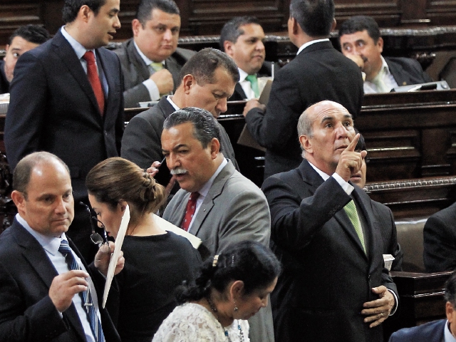 Mientras Manuel Conde explica a diputados del MR la iniciativa, Mario Taracena se cerciora de tener 105 votos. (Foto Prensa Libre: Esbin García)