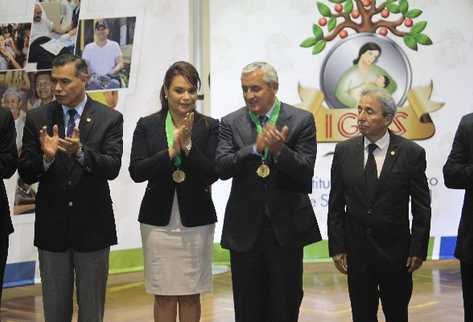 La vicepresidenta Roxana Baldetti  y el mandatario Otto Pérez aplauden al ser condecorados por Juan Rodríguez,  exsecretario  del presidente —izquierda—.