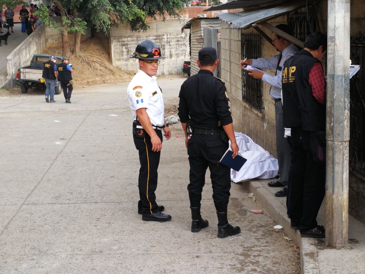 Bomberos y policías permanecen en la escena del crimen en Chinautla. (Foto Prensa Libre: Erick Avila)