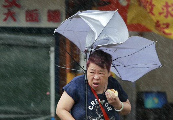 Una mujer luchas con su paraguas contra el fuerte viento generadas por el tifón Megi.(Foto Prensa Libre;AP).