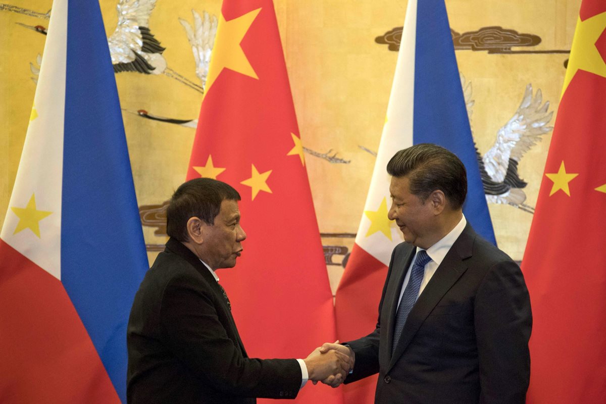 El presidente filipino, Rodrigo Duterte, (izquierda), estrecha la mano a su homólogo chino, Xi Jinping (izquierda), tras participar en una ceremonia de firma de acuerdos en Pekín (China). (Foto Prensa Libre: EFE).