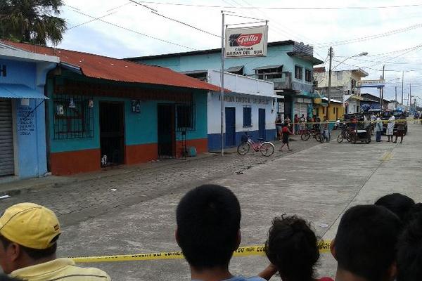 Curiosos observan el lugar en el que ocurrió ataque armado que dejó tres  muertos en Champerico. (Foto Prensa Libre: Rolando Miranda)