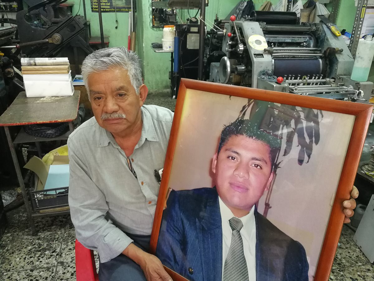 Óscar Israel Talé, en su taller de impresión, muestra una fotografía de su hijo César Iván Talé Cottom, quien fue secuestrado el 23 de octubre de 2008. (Foto Prensa Libre: Fred Rivera).