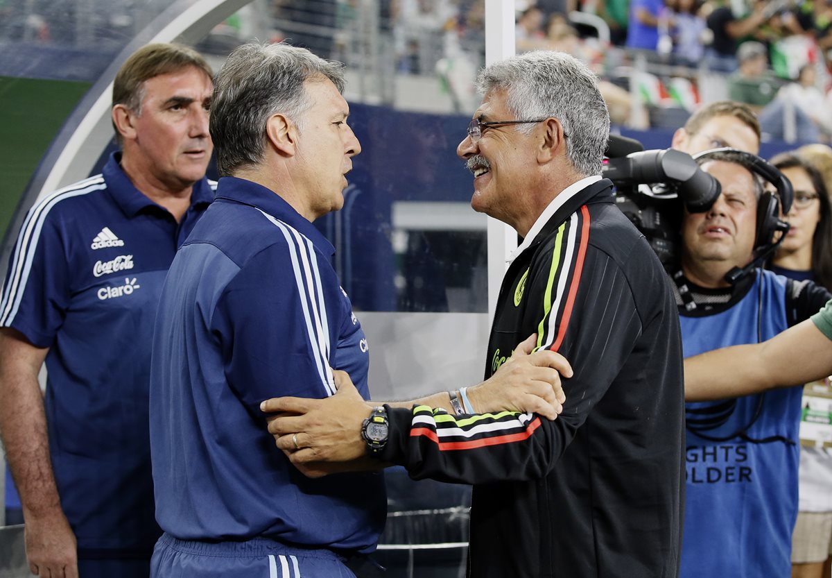 Martino y Ferreti comparten impresiones tras el juego amistoso entre las selecciones que dirigen. (Foto Prensa Libre: AP)