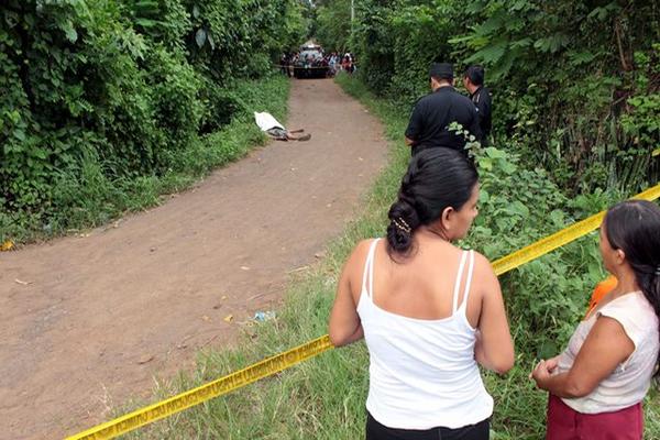 Curiosos observan el lugar donde quedó el cuerpo de Érick Alberto Calel González, en El Asintal, Retalhuleu. (Foto Prensa Libre: Rolando Miranda)