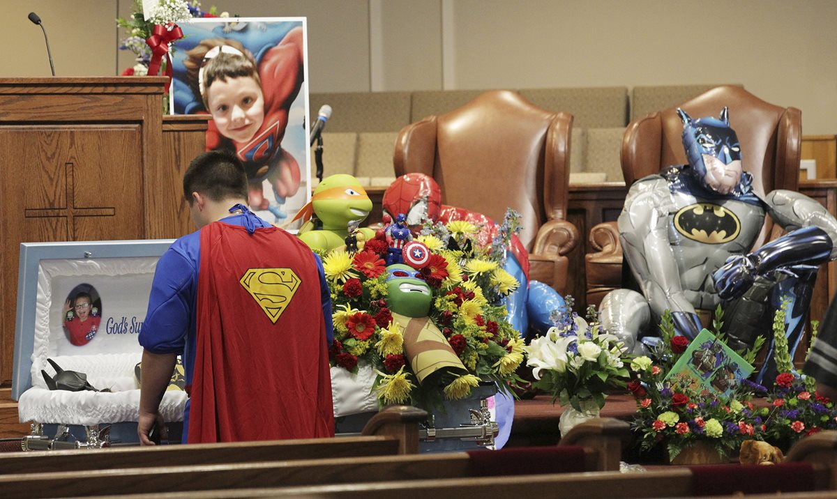 Dale Hall, hermano del pequeño Jacob Hall y vestido de superhéroe, lo despide durante su funeral. (Foto Prensa Libre: AP).