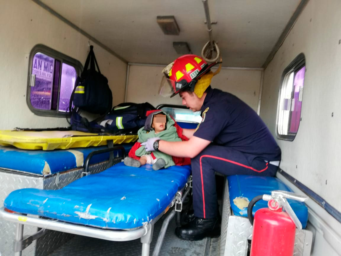 Bombero atiende a menor que fue lanzada desde mototaxi. (Foto Prensa Libre: Héctor Cordero).