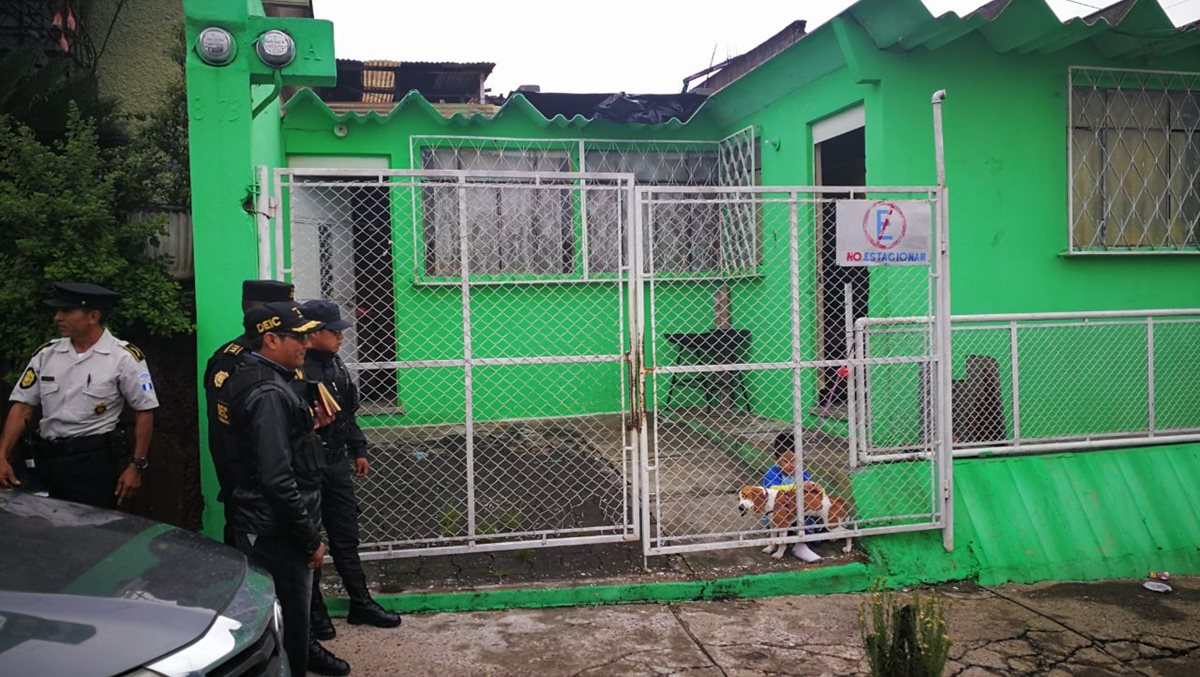 Un niño juega con su perro mientras las fuerzas de seguridad esperan afuera para realizar el allanamiento de una vivienda. (Foto Prensa Libre: Redacción)