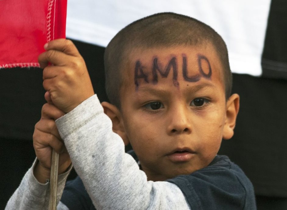 Se ve a un niño en la plaza del Zócalo mientras el nuevo presidente de México, Andrés Manuel López Obrador, aparece en una pantalla en su discurso de inauguración