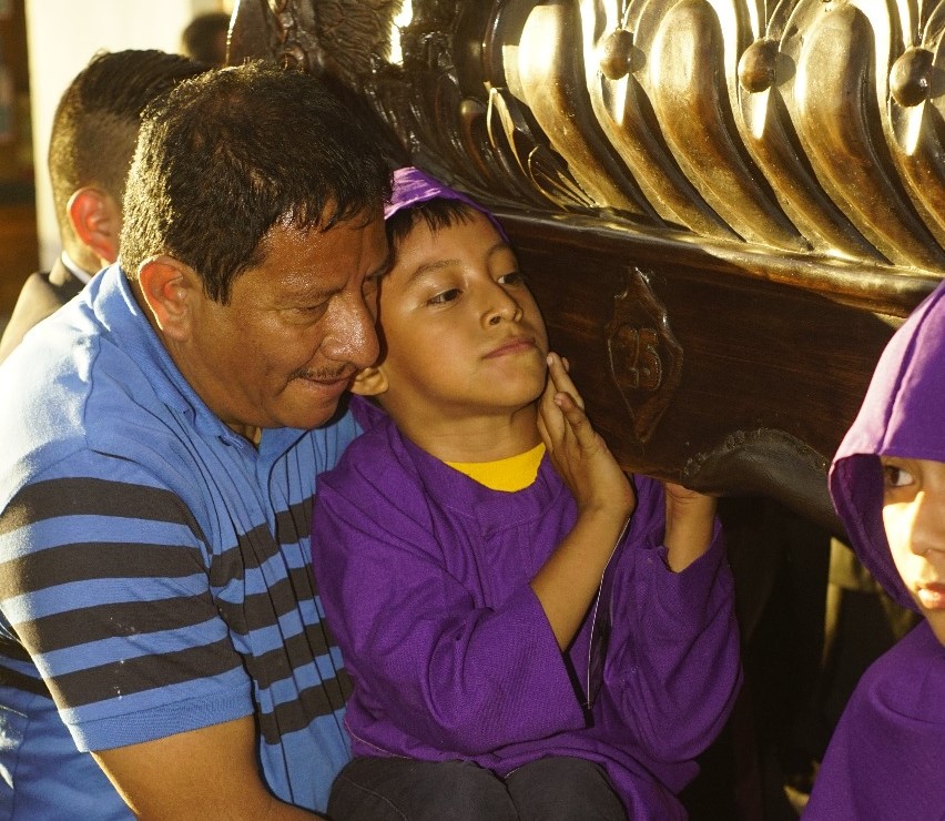Marvin Leonel Hernández carga a su hijo Natanael José David Hernández para que participe en procesión infantil en Antigua Guatemala. (Foto Prensa Libre: Roberto Masaya).