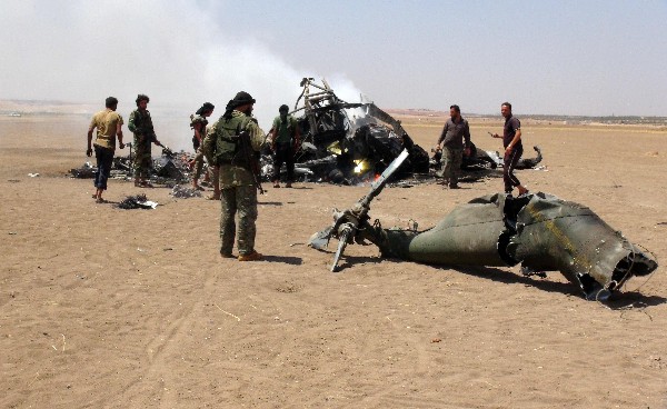 Rebeldes sirios observan los restos del helicóptero ruso Mi-8 derribado en Alepo. (Foto Prensa Libre: AFP)