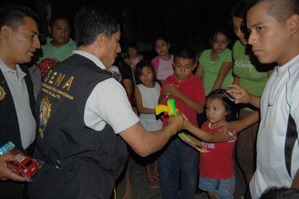 Personal de la PNC recibe una pistola de juguete de parte de una niña durante la jornada en Coatepeque. (Foto Prensa Libre: Alexánder Coyoy)<br _mce_bogus="1"/>