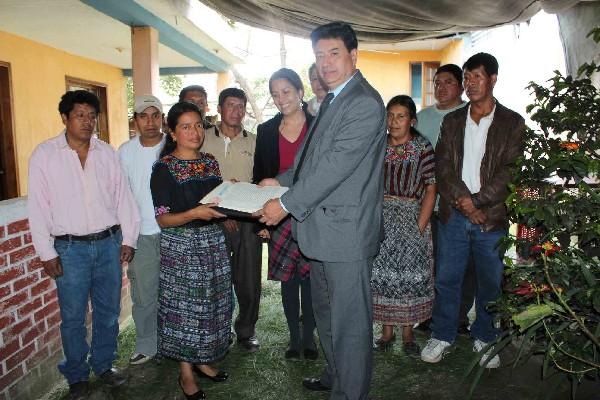 Josefina Coyote, presidenta de Asoju, recibe de Ubaldo Villatoro, de Conamigua,  el documento que legaliza la  asociación de  deportados de Patzún.