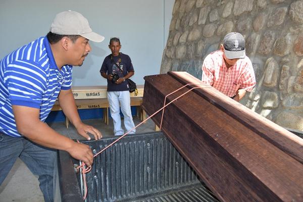 Dos empleados municipales retiran de la morgue de la ciudad de Zacapa el cadáver de Rigoberto López, quien murió de forma violenta en La Unión. (Foto Prensa Libre: Víctor Gómez)