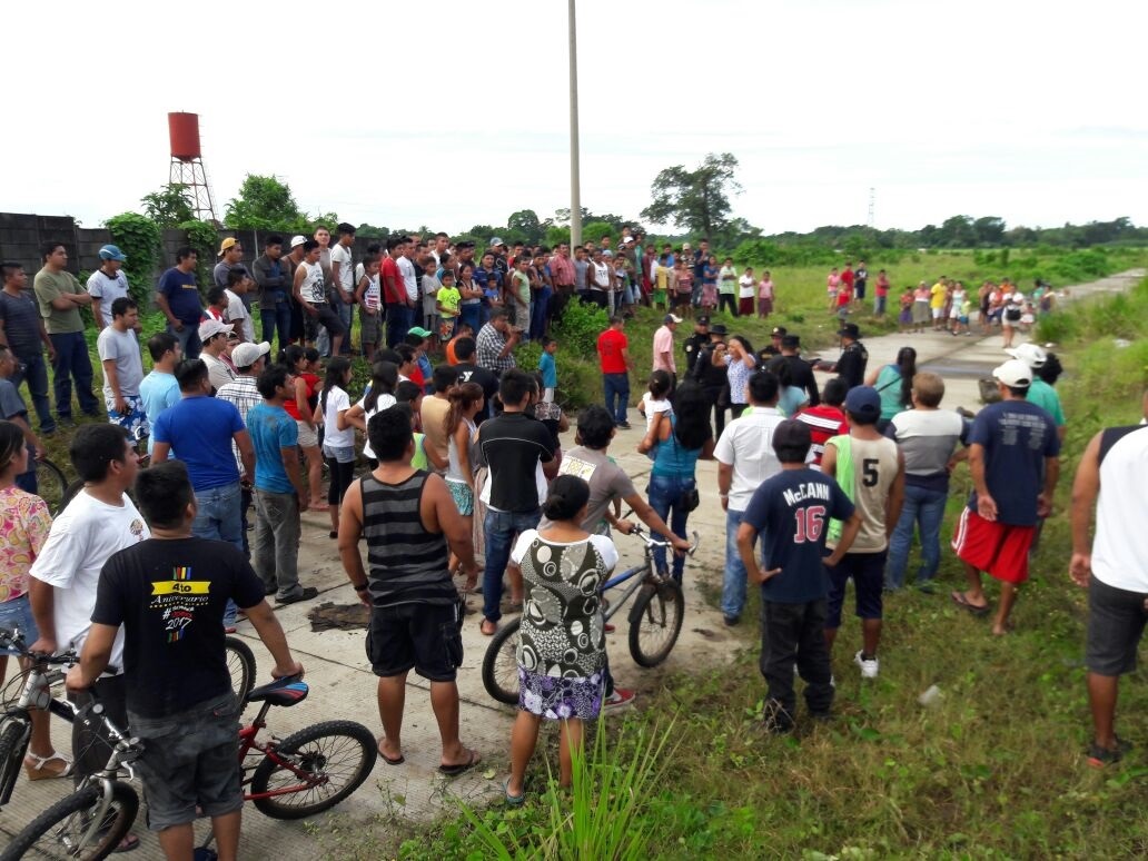 Vecinos llegan a identificar a las víctimas, quienes fueron ultimados en la entrada a la lotificación El Pedregal Cuyotenango, Suchitepéquez. (Foto Prensa Libre: Cristian Soto)