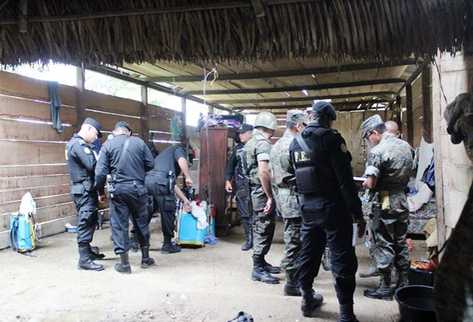 Ejército y Policía revisa la vivienda donde ocurrió la matanza de familia en San Luis, Petén. (Foto Prensa Libre: Rigoberto Escobar)