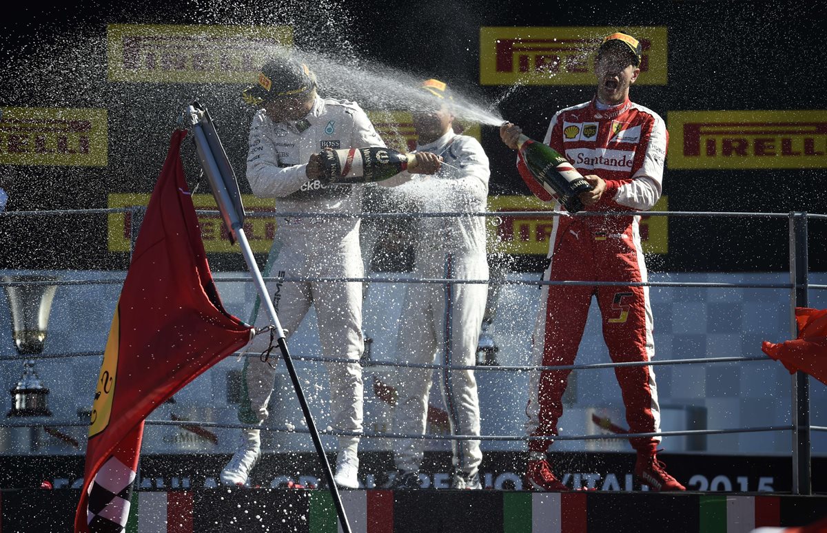 Lewis Hamilton festeja junto a los pilotos Sebastian Vettel y Williams Martini. Hamilton fue primero en el GP de Monza. (Foto Prensa Libre: AFP)
