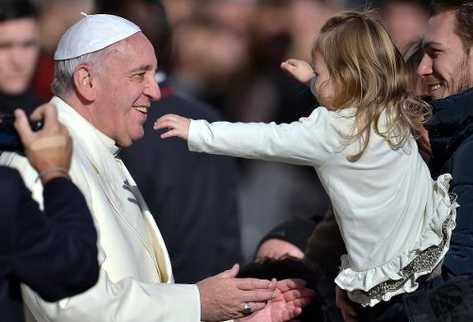 Una niña se echa a los brazos del papa Francisco durante la audiencia general del miércoles 4 de diciembre en la plaza de San Pedro del Vaticano. (Foto Prensa Libre: AFP)