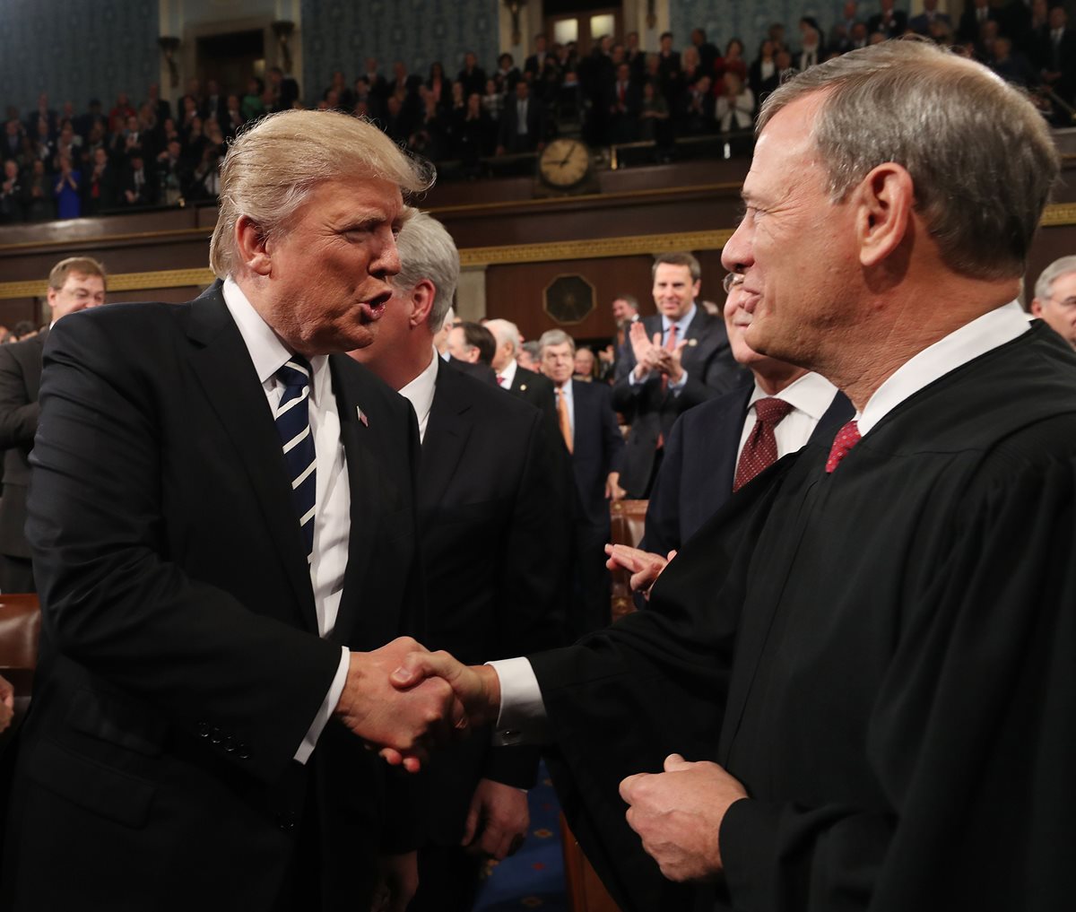 En esta foto de archivo de febrero del 2017, el presidente Donald Trump (izquierda) saluda al jefe de la Corte Suprema, John Roberts. (Foto Prensa Libre: AFP)