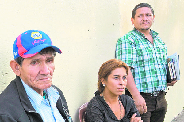 Padre  y hermano de Ana Luz Silva, junto a una vecina, esperan el cuerpo de la víctima frente a la morgue. (Foto Prensa Libre: Estuardo Paredes)